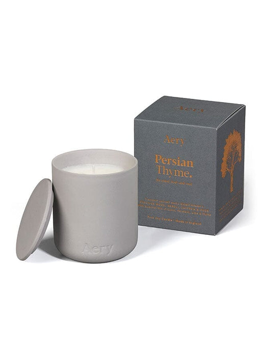 Grey Persian Thyme candle by Aery displayed next to product packaging on white bacground 
