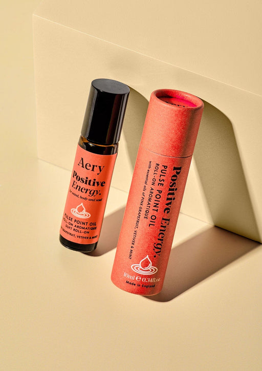 Positive Energy pulse point roll on with product packaging on cream bacground 