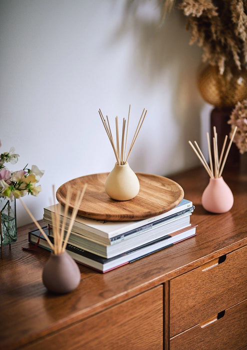 Himalayan Cedarleaf reed diffuser by aery displayed next to Moroccan Rose reed diffuser and Aztec Tuberose reed diffuser by aery placed on wooden side table 
